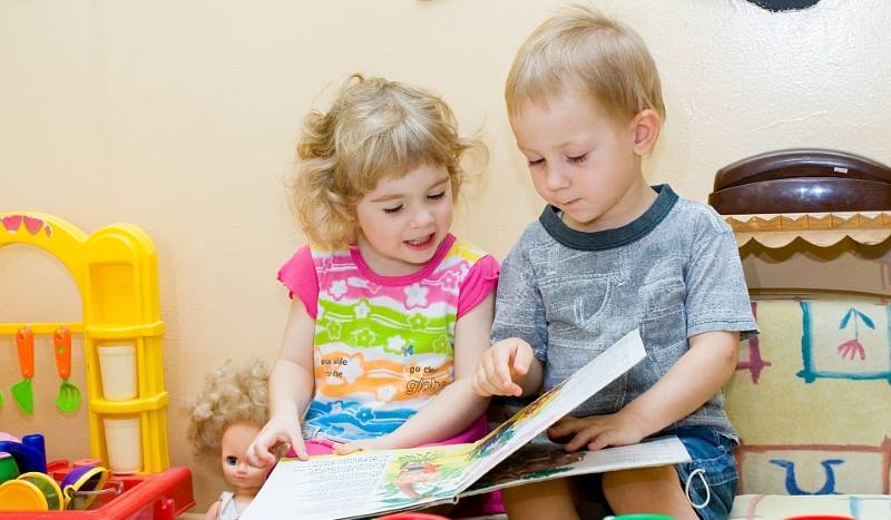 Девочка и мальчик листают книгу