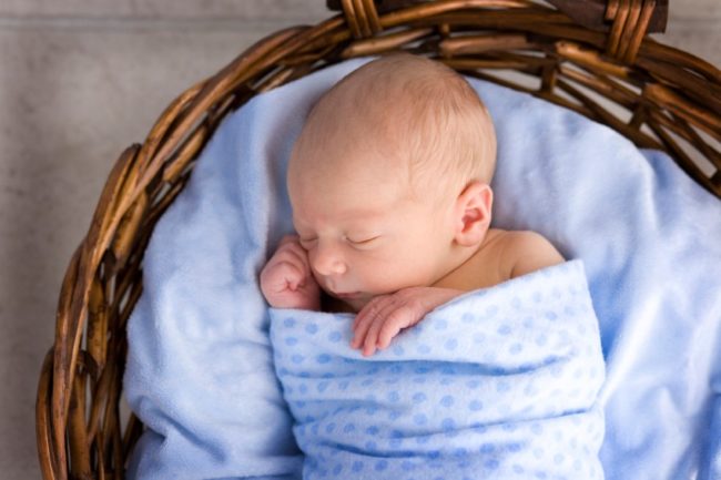 Новорождённый малыш в голубом одеяле
