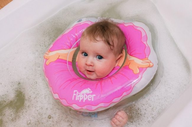 Младенец в воде с плавательным кругом