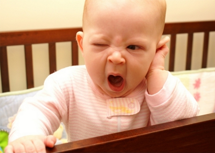 ребенок сидит зевает