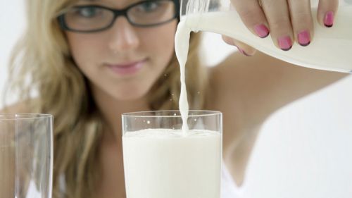 Девушка наливает молоко