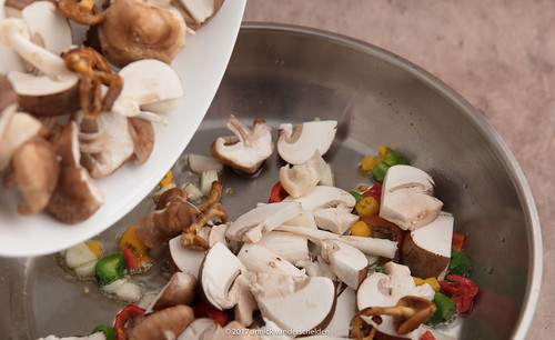 Adding mushrooms to fried chili pepper.