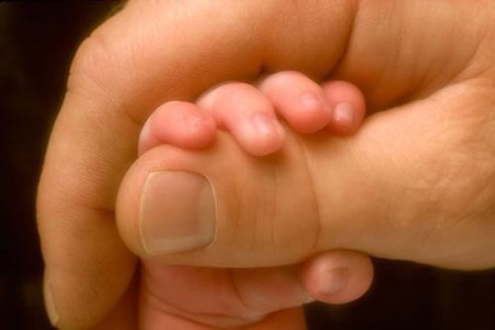 Мама держит руку ребёнка: для недоношенного важно чувствовать родителей