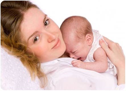 Новорожденный малыш плачет на маминых руках