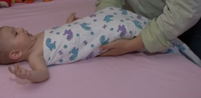 Правый и левый края пеленки подворачиваем малышу под спину
