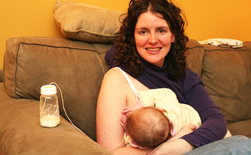 Женщина кормит ребёнка с помощью системы SNS