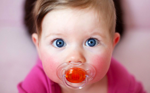 Малыш с огромными синими глазами и пустышкой во рту