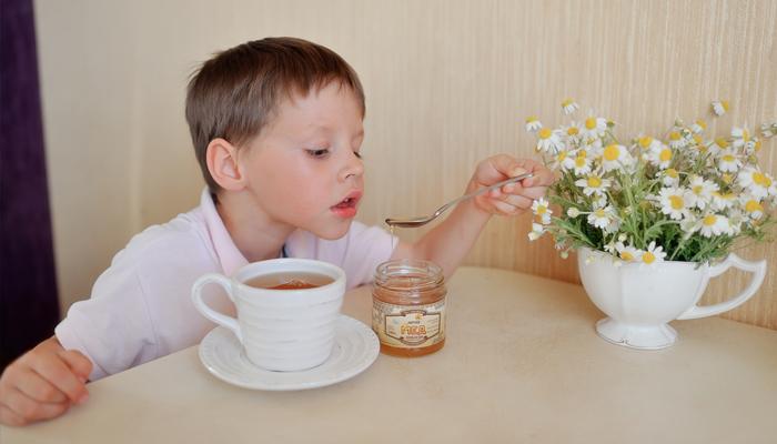 Ребенок пьет чай с медом