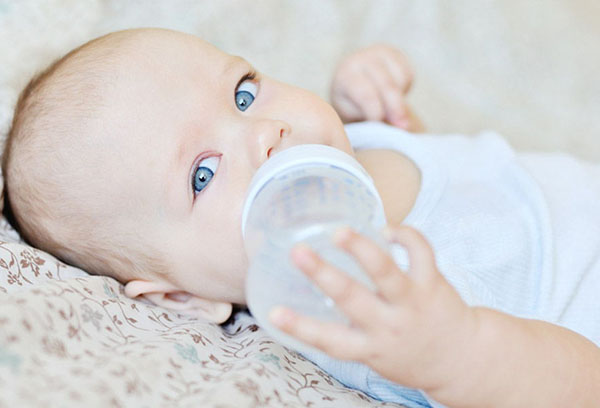 Ребенок пьет воду из бутылочки